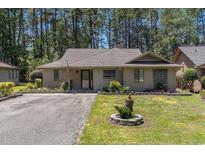 Charming single-story home featuring a well-manicured lawn and inviting curb appeal nestled amongst the trees at 137 Hickory Dr., Conway, SC 29526