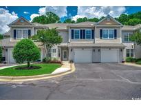 Charming townhome featuring a well-manicured lawn, attached garage, and classic architectural details at 2450 Marsh Glen Dr. # 112, North Myrtle Beach, SC 29582