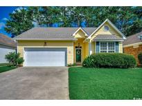Charming yellow single-story home with a well-manicured lawn, attached garage, and inviting curb appeal at 2602 Clearwater St., Myrtle Beach, SC 29579