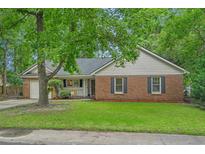 Charming brick and siding home with lush landscaping and a welcoming front porch at 311 Ashwood Ln., Myrtle Beach, SC 29588