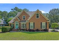 Charming two-story brick home with a well-manicured lawn and a welcoming blue front door and black shutters at 3975 River Hills Dr., Little River, SC 29566