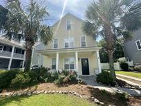 Charming two-story home featuring a front porch framed by palm trees and lovely landscaping at 433 Emerson Dr., Myrtle Beach, SC 29579