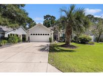 Charming single-story home with a well-manicured lawn, palm tree and an attached two car garage at 4610 Fringetree Dr., Murrells Inlet, SC 29576