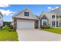 Charming home with stone and siding accents, white garage door, and well-manicured lawn at 490 Calhoun Falls Dr., Myrtle Beach, SC 29579