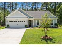 Charming single-story home featuring a two-car garage, well-manicured lawn, and inviting curb appeal at 589 Boundaryline Dr. Nw, Calabash, NC 28467