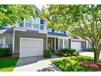 Charming two-story townhome featuring an attached garage, balcony, and well-maintained landscaping at 6172 Catalina Dr. # 113, North Myrtle Beach, SC 29582