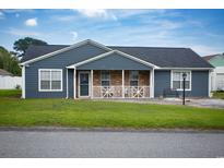 Charming single-story home with blue siding, front porch, and well-maintained lawn at 890 Holly Sands Blvd., Little River, SC 29566