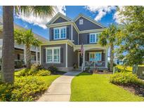 Charming two-story home with a welcoming front porch, well-manicured lawn, and beautiful landscaping at 966 Crystal Water Way, Myrtle Beach, SC 29579