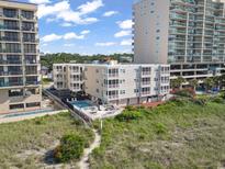 Coastal condo with a pool, deck, and beach access nestled between two larger condo buildings at 1011 S Ocean Blvd. # 301, North Myrtle Beach, SC 29582