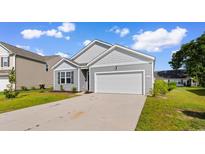 Charming single-story home featuring gray siding, an attached garage, and a well-maintained lawn at 1128 Sennema Circle, Myrtle Beach, SC 29588