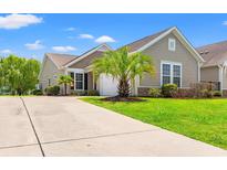 Charming single-story home with a manicured lawn, large driveway, and attached two-car garage at 1590 Palmina Loop # A, Myrtle Beach, SC 29588