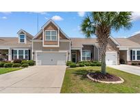 Charming two-story home with a tan exterior, stone accents, landscaped yard, and a spacious two-car garage at 178 Parmalee Dr. # C, Murrells Inlet, SC 29576