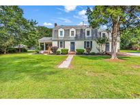Charming two-story home with dormers, landscaped yard, and inviting front porch, creating a welcoming curb appeal at 203 Lakeland Dr., Conway, SC 29526