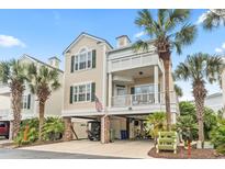 Charming two-story home with a front porch and covered parking under the house with palm trees at 208 Millwood Dr., Surfside Beach, SC 29575