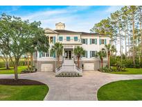 Stately home with well manicured yard, palm trees, symmetrical facade and white exterior with blue shutters at 288 Tipperary Pl., Pawleys Island, SC 29585
