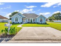 Charming light blue home with landscaped front yard, driveway, and well-maintained lawn at 3907 Stillwood Dr., Myrtle Beach, SC 29588