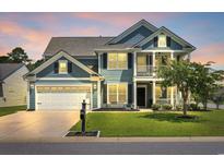 Charming two-story home with a well-manicured lawn, two car garage, and inviting front porch and a balcony above at 3925 Riley-Hampton Dr., Myrtle Beach, SC 29579