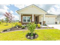 Charming home featuring stone accents, a well-manicured lawn, and a welcoming front porch at 435 Rollins Dr., Longs, SC 29568