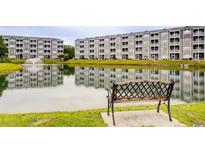 Scenic view of condos overlooking a pond with a fountain and a bench in the foreground at 4522 N Plantation Harbour Dr. # E7, Little River, SC 29566