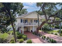 Charming two-story home features a spacious porch, lovely landscaping, and a brick driveway leading to ample parking at 505 41St Ave. S, North Myrtle Beach, SC 29582