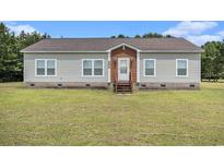 Charming single-story home with vinyl siding, a brick foundation, and well-manicured lawn at 580 Circle M Rd., Longs, SC 29568