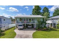 Charming two-story home featuring a covered porch, driveway parking, and a beautifully landscaped front yard at 5867 Rosewood Dr., Myrtle Beach, SC 29588