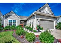 Charming home featuring manicured landscaping, gray siding, and a welcoming front entrance at 6430 Cascata Dr., Myrtle Beach, SC 29572