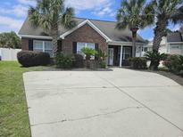 Charming brick home with palm trees and a spacious driveway at 1028 Cherry Tree Ln., North Myrtle Beach, SC 29582