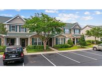 Charming townhome featuring brick accents, green shutters, well-maintained landscaping, and dedicated parking at 155 Chenoa Dr. # D, Murrells Inlet, SC 29576
