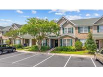 Charming townhome exterior with lush landscaping, green shutters and a well-manicured lawn at 155 Chenoa Dr. # E, Murrells Inlet, SC 29576