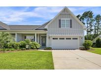 Charming single-Gathering home featuring an attached two-car garage, well-manicured lawn, and inviting curb appeal at 1584 Sand Harbor Cir. # 1584, Ocean Isle Beach, NC 28469