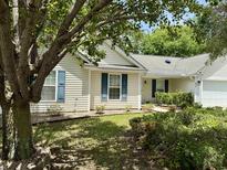 Charming single-story home with light siding, blue shutters, and mature landscaping at 233 Melody Gardens Dr., Surfside Beach, SC 29575