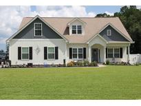 Charming two-story home with a well-manicured lawn and inviting curb appeal with flower beds at 242 Four Mile Rd., Conway, SC 29526