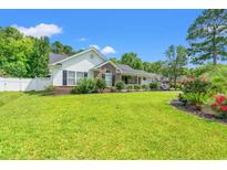 Charming one-story home boasts a well-manicured lawn, beautiful landscaping, and welcoming front porch at 2529 Hunters Trail, Myrtle Beach, SC 29588