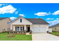 Charming one-story home features a manicured lawn, two-car garage, and covered entry way at 703 Laconic Dr., Myrtle Beach, SC 29588