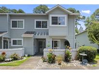Charming two-story home with light gray siding and a well-manicured front yard with tasteful landscaping at 81 Shadow Moss Pl. # 81, North Myrtle Beach, SC 29582