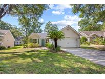 Charming one story home featuring a well-manicured lawn and a two-car garage at 83 Reef Run Rd., Pawleys Island, SC 29585