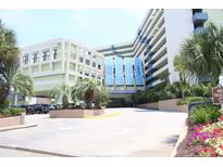 The Coral Beach Resort features an inviting entrance, showcasing tropical landscaping and covered parking at 1105 S Ocean Blvd. # 218, Myrtle Beach, SC 29577