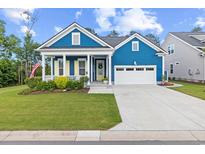 Charming blue home features a well-manicured lawn, covered porch, and two car garage at 117 Black Water Dr., Murrells Inlet, SC 29576