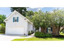 Charming home featuring a two-car garage, brick accents, and mature landscaping, offering great curb appeal at 1409 Ashwood Circle, Surfside Beach, SC 29575