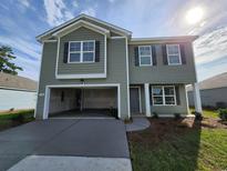 Charming two-story home features an attached garage, gray siding, and well-maintained landscaping at 190 Belmonte Dr., Myrtle Beach, SC 29588
