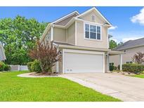 A charming two-story home features a large garage, neutral siding, and a well-manicured lawn at 276 Whipple Run Loop, Myrtle Beach, SC 29588