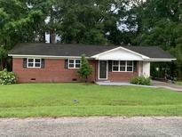 Charming one-story brick home with well-maintained lawn and mature trees at 3110 Pinewood Dr., Loris, SC 29569