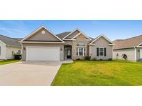 Charming home featuring a two-car garage, manicured lawn, and a blend of stone and vinyl siding at 347 Leste Rd., Myrtle Beach, SC 29588