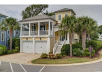 Charming yellow two-story home with a brick driveway and lush tropical landscaping at 4986 Salt Creek Ct., North Myrtle Beach, SC 29582