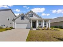 Charming single-Gathering home with a well-manicured lawn, welcoming front porch, and attached two-car garage at 534 Calhoun Falls Dr., Myrtle Beach, SC 29579