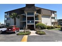 Condo building with a well-maintained lawn and mature trees in a coastal community at 5601 N Ocean Blvd. # B-314, Myrtle Beach, SC 29577