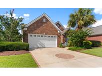Charming single story brick home with a well manicured lawn, lush landscaping and a two car garage at 5712 Whistling Duck Dr., North Myrtle Beach, SC 29582