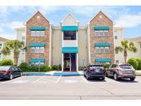 Apartment complex featuring covered balconies, parking, and blue awnings adding a pop of color at 9755 Leyland Dr. # 2, Myrtle Beach, SC 29572