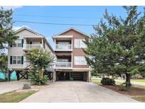 Beautiful coastal home featuring a two-story exterior with covered parking and private balconies at 121B 7Th Ave. S, Surfside Beach, SC 29575